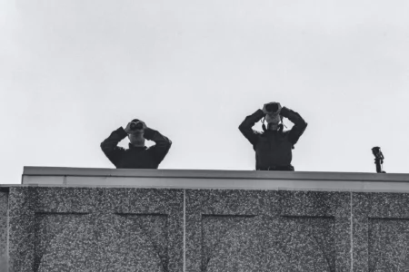Zwei Männer stehen auf dem Dach mit Fernglas